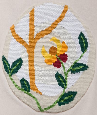 Detalj fra vevde hvite kirketekstiler. Kors og blomster